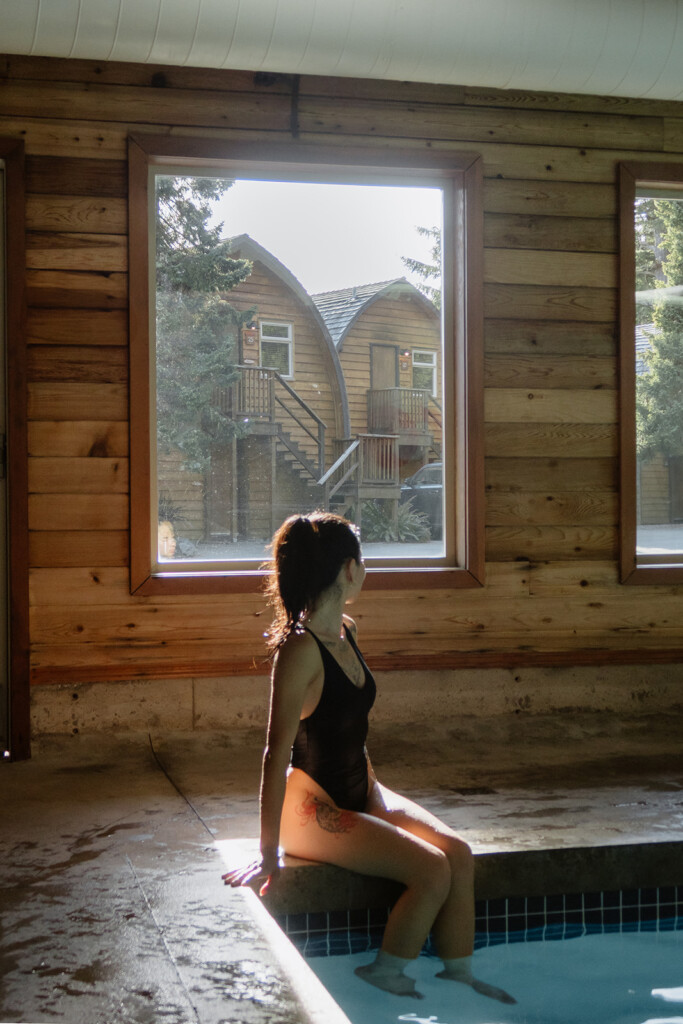 Girl sitting on edge of pool in contemplation
