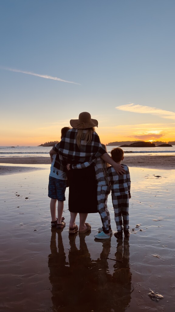 Family gathers for a hug while watching sunset over Tinwis beach